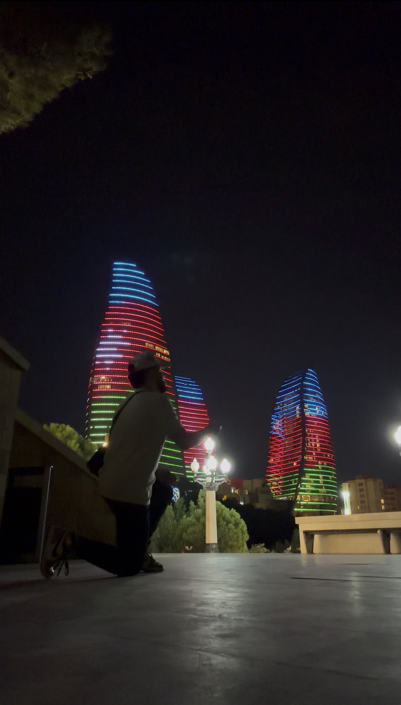 Gio frente a las Flame Towers iluminadas en Bakú, Azerbaiyán